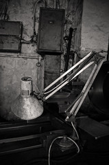 Dirty old lamp in workshop. Black and white photo of lamp in old workshop.