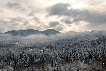 mountain winter view with sun and clouds