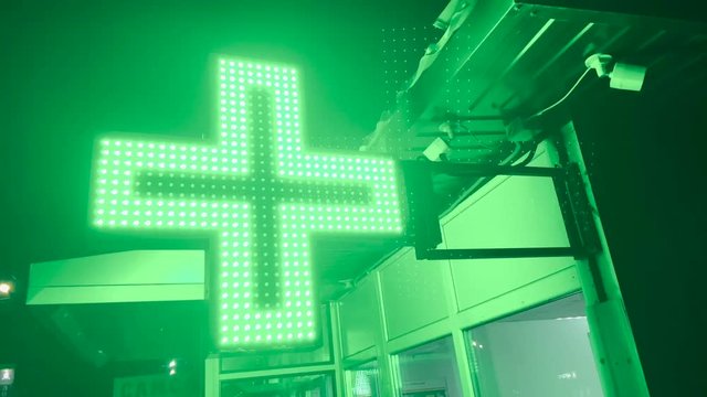 Close up of green illuminated pharmacy sign 4k late dark evening or night