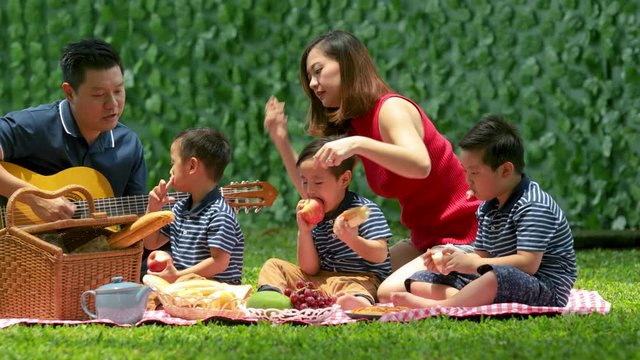 Happy family picnicking and enjoying food at park