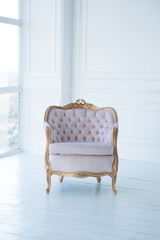 pink armchair with a gold rim in a white room