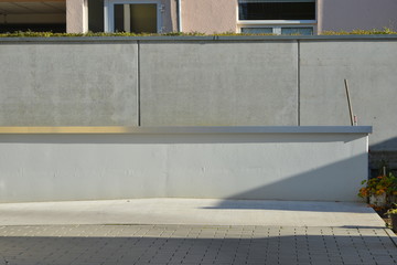 Neue ungestrichene Betonmauer mit Edelstahl-Abschlussblech der Mauerkrone als Wetterschutz an der...