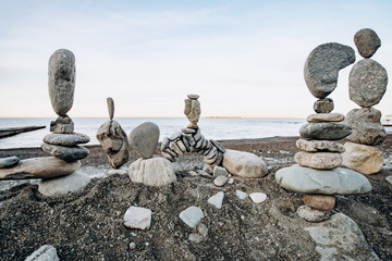 Figures of stones on the beach. Beautiful figures of stones on the background of the sea. - obrazy, fototapety, plakaty