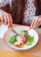 woman eating roasted vegetables in the cafe
