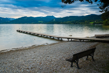 Wooden pier and bench in the beach of Tegernsee lake near Gmund am Tegernsee in Germany
