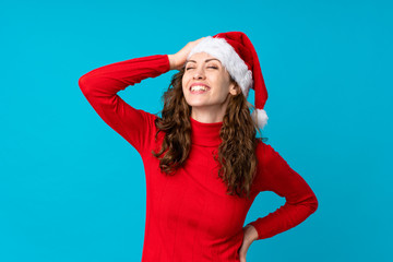 Girl with christmas hat over isolated yellow background laughing