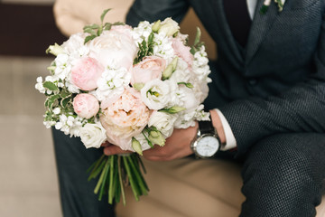 Wedding bouquet in the hands of the groom, selective focus