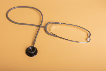 Stethoscope with gray rubber, on mustard colored background