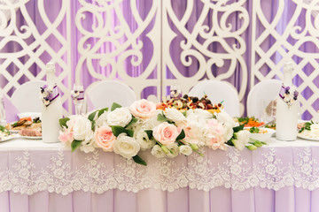 The concept of decor for weddings and holidays, floral arrangements on the tables, the Presidium of the newlyweds in purple