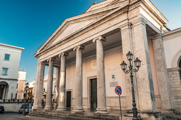 The cathedral of San Pietro Apostolo in Isernia. The facade with a large triangular tympanum in travertine, supported by pillars and columns with Ionic capitals. The portal with bas-reliefs.