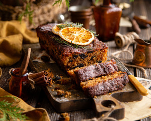 homemade traditional christmas fruit cake cut on slices with fruits, nuts, dried citrus