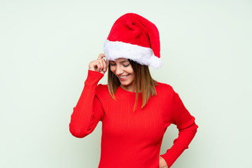 Girl with christmas hat over isolated green background laughing