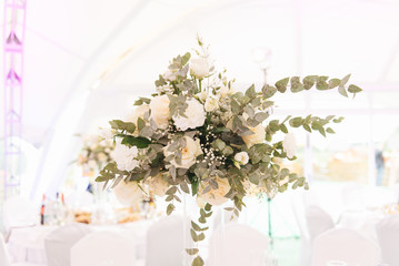 The concept of decoration for wedding and celebration, a beautiful white tent decorated with flowers for the holiday