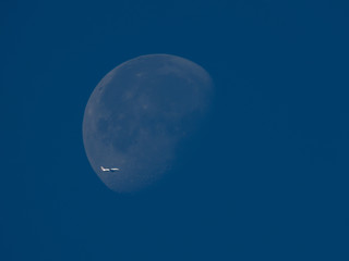 Obraz na płótnie Canvas avion qui passe devant la lune