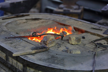 Hot coals in a furnace for heating metal for manual forging in a blacksmith workshop