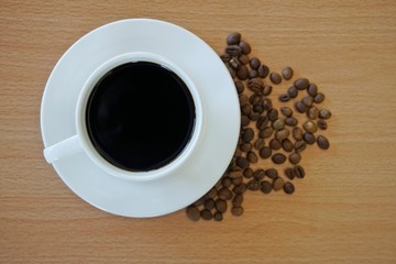 cup of coffee and beans on wooden table