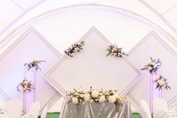 Decor concept for wedding and holiday, beautiful white tent decorated with flowers for the holiday, Presidium with diamonds of the bride and groom