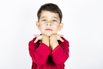 Young boy with a serious face and sad beautiful eyes on a light background. Copy space