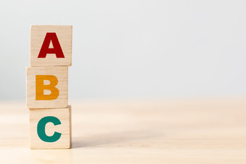 ABC-letters alfabet op houten kubusblokken in pilaarvorm op houten tafel