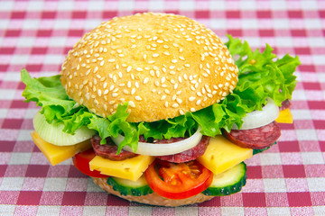 Hamburger with vegetables and sausage. Fast food and breakfast. Calories and diet.