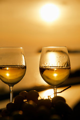 two glasses with wine during sunset time