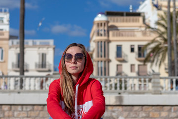 Fototapeta premium Pretty blonde girl on the beach with red jersey on the beaches of Barcelona