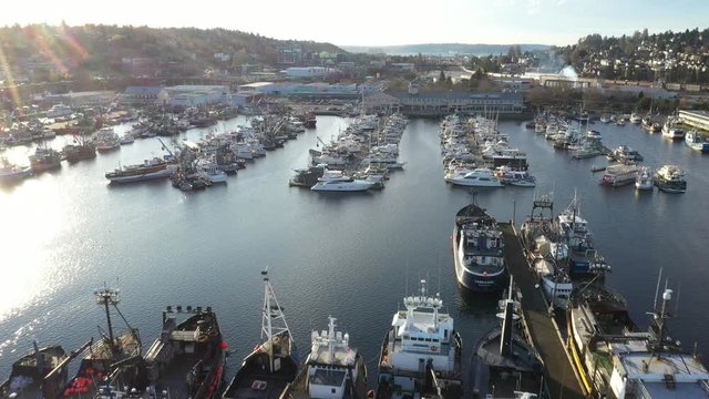 Drone footage of Fishermen's Terminal at Salmon Bay near Ballard, Puget Sound with fishing boats ships and yachts and Elliott Bay in the background