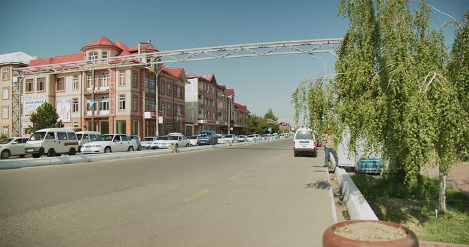 Street in Andijan city Fergana valley. Moving cars and housing. Uzbekistan, Central Asia.