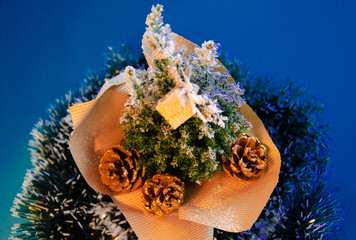 Top view of christmas tree covered snow decorations with pinecone on phantom blue background. copy space