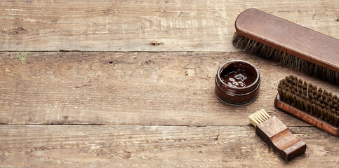 Brush for shoes. Cleaning and polishing shoes with brushes. Shoe polish and brush on wooden background. Copy space for text.