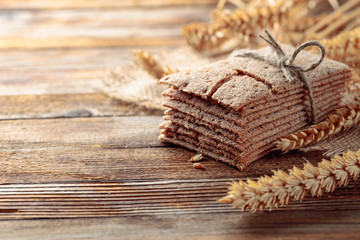 Rye crackers and ears on a old wooden table.