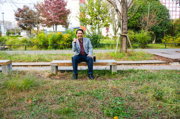 Fototapeta premium man sitting on a bench in the park