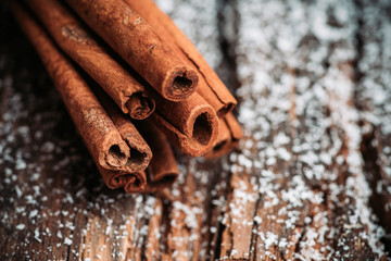 Christmas setting with bundle of cinnamon, anise stars and other christmas decorations on the rustic wooden background. Selective focus. Shallow depth of field.