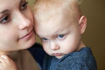 Mom gently snuggles up to her little son, close-up.