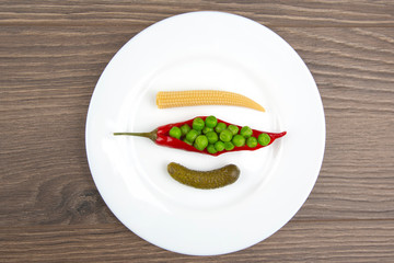 salad of pickled and pickled corn, peas, cucumber and red pepper on a white plate.