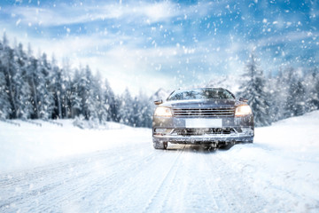 Gray winter car on road with snow.Free space for your decoration.Snowflakes and forest of...