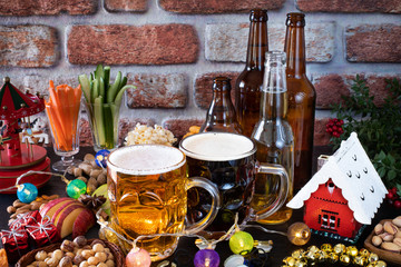 Beer glasses and beer bottles with appetizer on the table like almonds