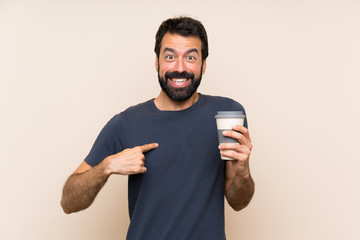 Man with beard holding a coffee with surprise facial expression