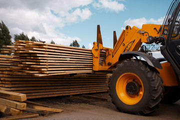 Forklift loads the boards in the lumber yard
