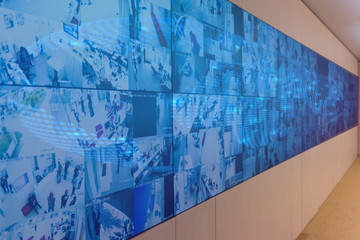 Security guard monitoring modern CCTV cameras in surveillance room.