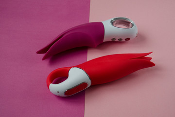 Vibrators. Pink and red dildos with vibration. Sex toys for women on color background. Useful for adult - obrazy, fototapety, plakaty