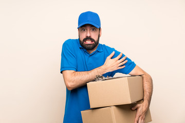 Delivery man with beard over isolated background freezing