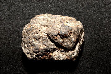 Iron-stone meteorite on a black background