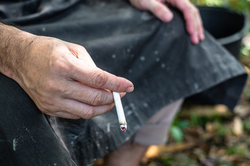 Close up of male hand holding a cigarette.