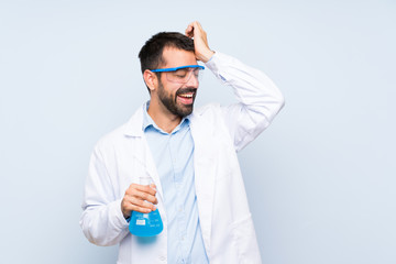 Young scientific holding laboratory flask over isolated background has realized something and intending the solution