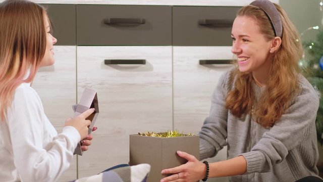 Christmas surprise. New Year celebration. Teen girl happy to receive gift from female bbf.