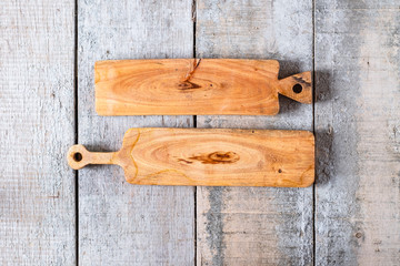 Empty rectangular long rubber wood cutting boards with shellac coating on rustic wooden background , top view. Flat lay background.