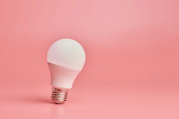 Light bulb, copy space. Energy saving minimal idea concept.Pink background.