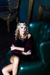 Fototapeta na wymiar young blond woman wearing crown in fairy luxury interior with empty antique frames total wealth concept