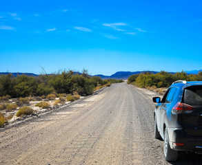 Obraz na płótnie Canvas Dirty car in desert on unpaved road. Death Valley National Park road trip